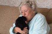 Lady kissing small dog