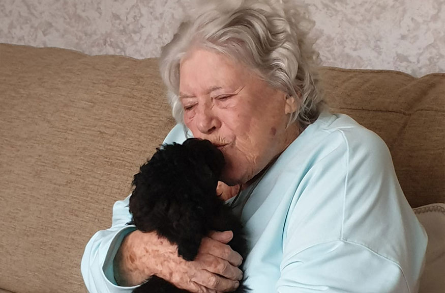 Lady kissing small dog